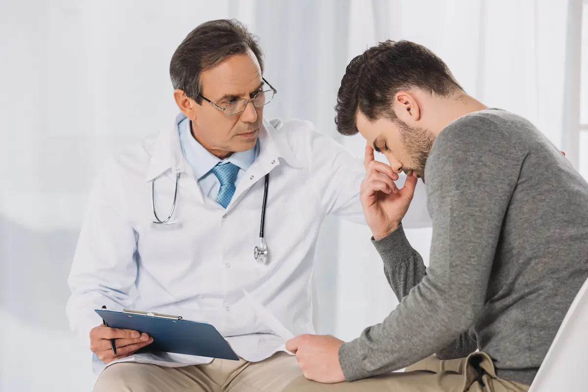 A man sees his doctor to discuss his mental health.