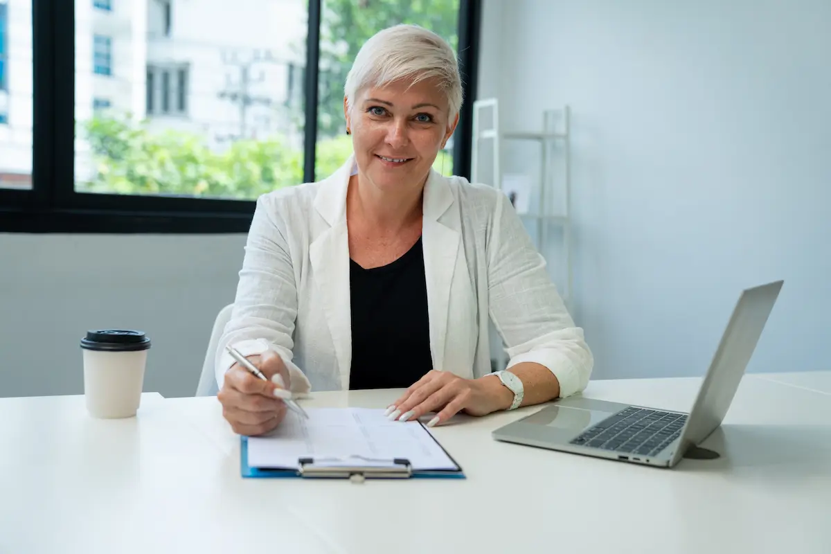 A female school leader sits behind her desk on Principal’s Day.