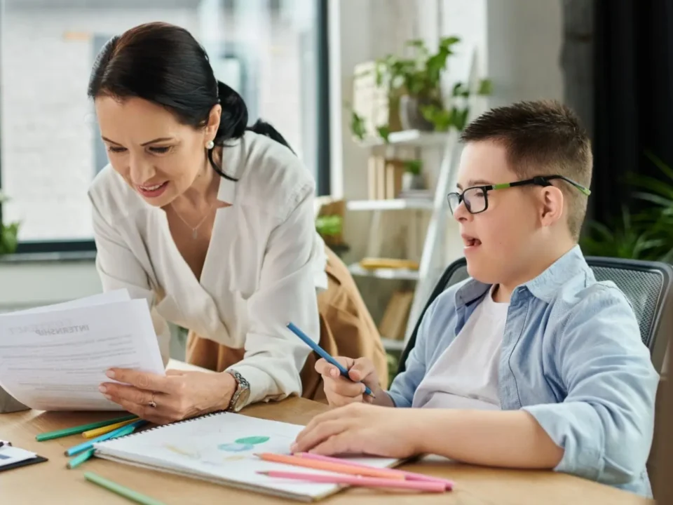 Smiling teacher teaching a student with down syndrome.